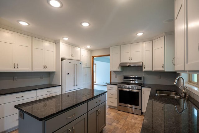 2851 120th Ave SW, Willmar, MN 56201 - kitchen featuring gas range, freestanding refrigerator, a sink, under cabinet range hood, and white cabinetry