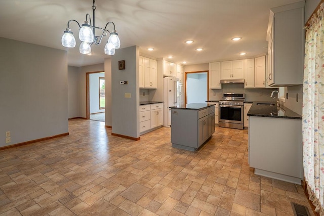 2851 120th Ave SW, Willmar, MN 56201 - kitchen with stainless steel range oven, a sink, under cabinet range hood, a center island, and baseboards