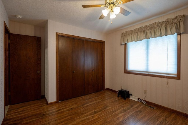 2851 120th Ave SW, Willmar, MN 56201 - unfurnished bedroom with wood finished floors, a closet, baseboards, and a ceiling fan
