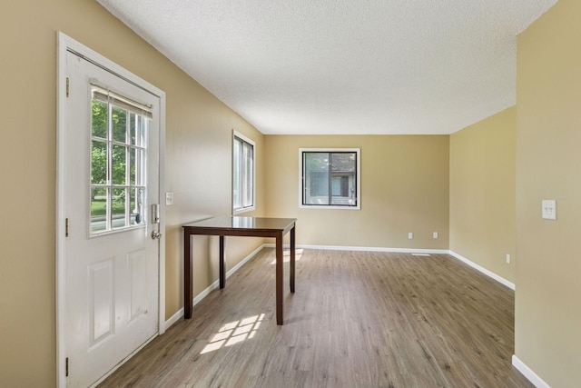 6670 84th Ct N, Brooklyn Park, MN 55445 - empty room featuring a textured ceiling, wood finished floors, and baseboards