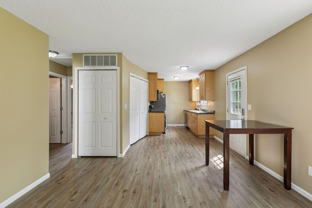 6670 84th Ct N, Brooklyn Park, MN 55445 - kitchen featuring baseboards, wood finished floors, dark countertops, and a sink