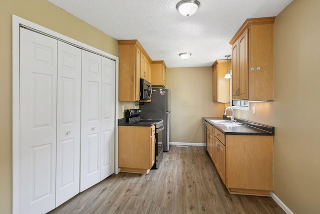 6670 84th Ct N, Brooklyn Park, MN 55445 - kitchen featuring range with electric cooktop, stainless steel microwave, a sink, baseboards, and wood finished floors