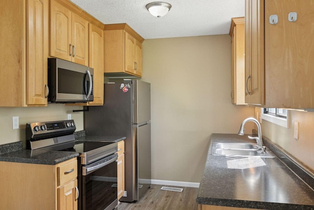 6670 84th Ct N, Brooklyn Park, MN 55445 - kitchen featuring appliances with stainless steel finishes, a sink, dark wood-type flooring, dark countertops, and baseboards