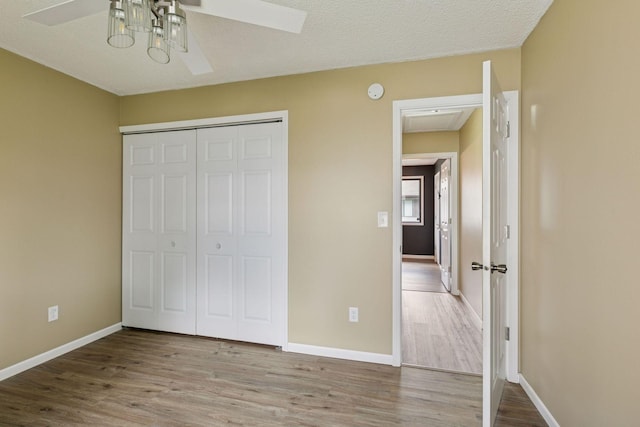 6670 84th Ct N, Brooklyn Park, MN 55445 - unfurnished bedroom featuring wood finished floors, a closet, baseboards, and a ceiling fan