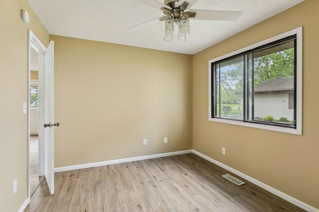 6670 84th Ct N, Brooklyn Park, MN 55445 - unfurnished room with light wood finished floors, baseboards, a ceiling fan, and a textured ceiling