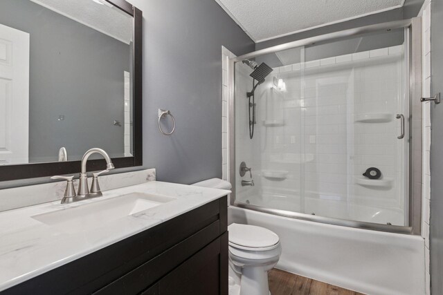 6670 84th Ct N, Brooklyn Park, MN 55445 - full bath featuring vanity, toilet, shower / bath combination with glass door, wood finished floors, and a textured ceiling