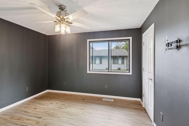 6670 84th Ct N, Brooklyn Park, MN 55445 - spare room featuring wood finished floors, a textured ceiling, ceiling fan, and baseboards