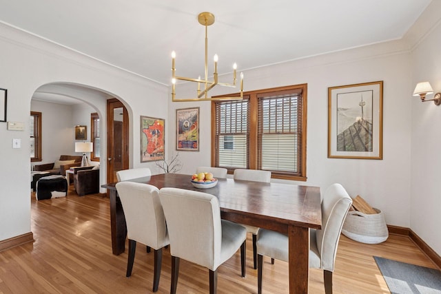 5117 48th St, Edina, MN 55436 - dining space featuring arched walkways, light wood-style flooring, a chandelier, baseboards, and ornamental molding
