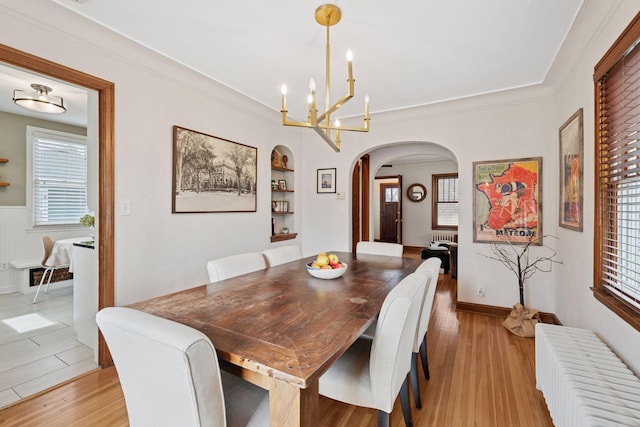 5117 48th St, Edina, MN 55436 - dining room with radiator heating unit, arched walkways, a chandelier, light wood-type flooring, and crown molding