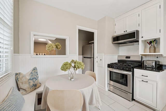 5117 48th St, Edina, MN 55436 - kitchen with stainless steel appliances, a wainscoted wall, white cabinetry, and open shelves