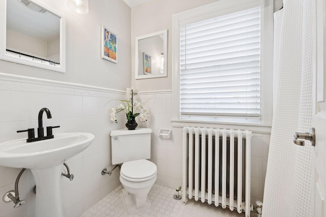 5117 48th St, Edina, MN 55436 - bathroom with radiator, toilet, tile walls, a wainscoted wall, and a shower with shower curtain