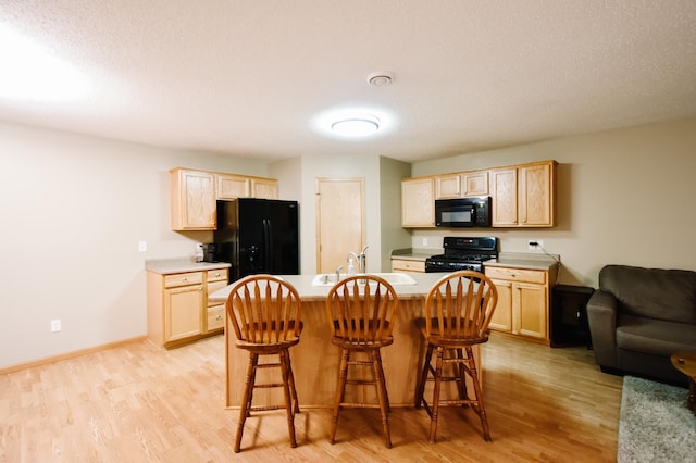2778 Ridgeview Ln, Red Wing, MN 55066 - kitchen with black appliances, light brown cabinetry, a sink, and light wood-type flooring