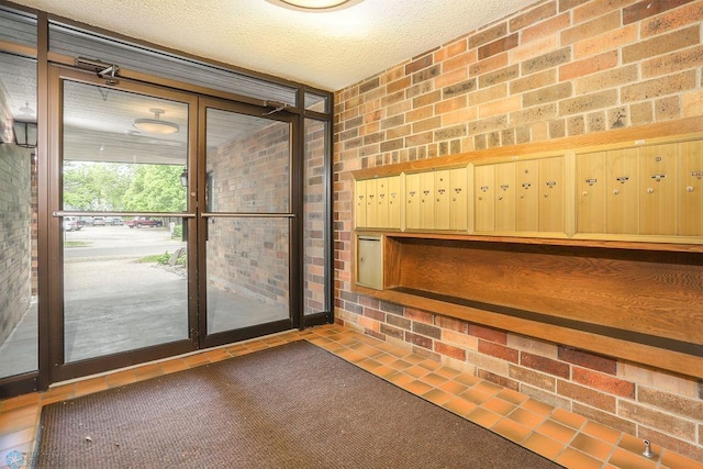220 8th St S Unit B2, Fargo, ND 58103 - doorway to outside featuring brick wall and a textured ceiling