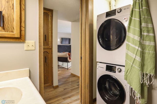 220 8th St S Unit B2, Fargo, ND 58103 - washroom with estacked washer and dryer, light wood finished floors, a sink, and baseboards