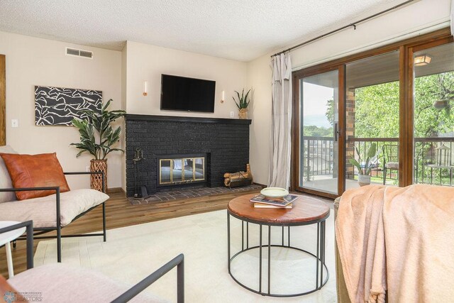 220 8th St S Unit B2, Fargo, ND 58103 - living area featuring wood finished floors, a textured ceiling, and a fireplace