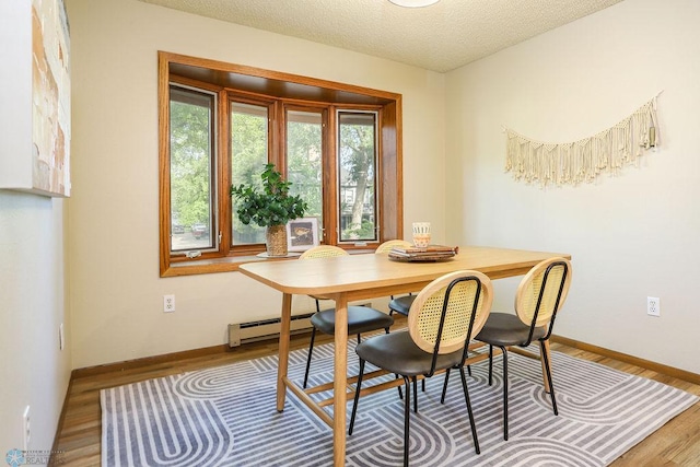 220 8th St S Unit B2, Fargo, ND 58103 - dining room with a baseboard heating unit, wood finished floors, baseboards, and a textured ceiling