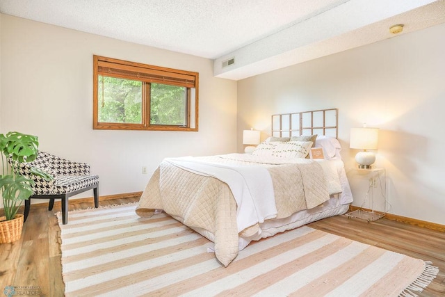 220 8th St S Unit B2, Fargo, ND 58103 - bedroom with wood finished floors, baseboards, and a textured ceiling
