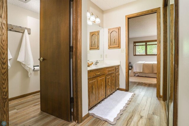 220 8th St S Unit B2, Fargo, ND 58103 - ensuite bathroom with vanity, wood finished floors, a textured ceiling, and baseboards