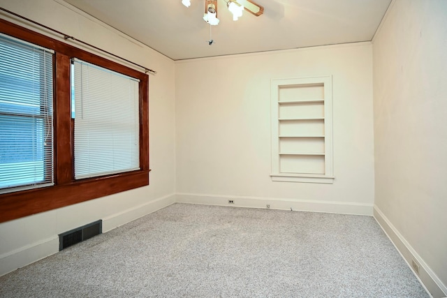 919 Howard St, Winona, MN 55987 - unfurnished room featuring built in shelves, carpet floors, ceiling fan, and baseboards