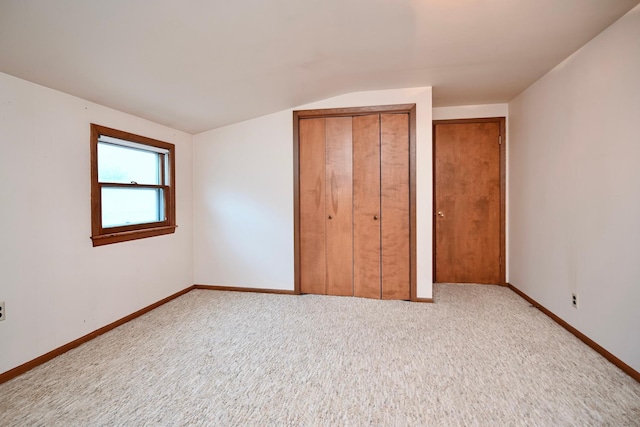 919 Howard St, Winona, MN 55987 - unfurnished bedroom featuring carpet flooring, lofted ceiling, baseboards, and multiple closets