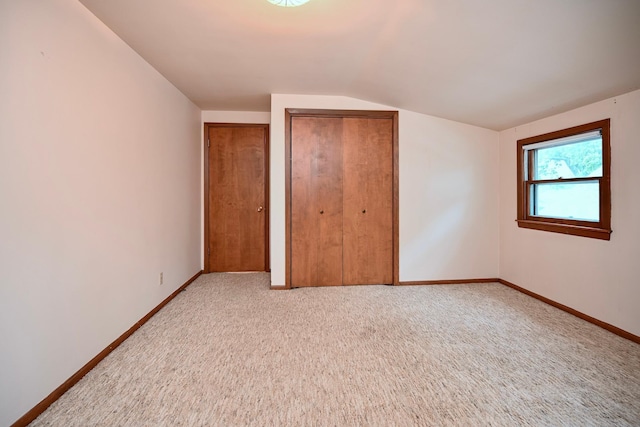 919 Howard St, Winona, MN 55987 - unfurnished bedroom with vaulted ceiling, baseboards, carpet floors, and multiple closets