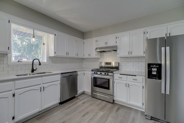 4207 Fillmore St NE, Columbia Heights, MN 55421 - kitchen with appliances with stainless steel finishes, a sink, under cabinet range hood, white cabinetry, and light countertops