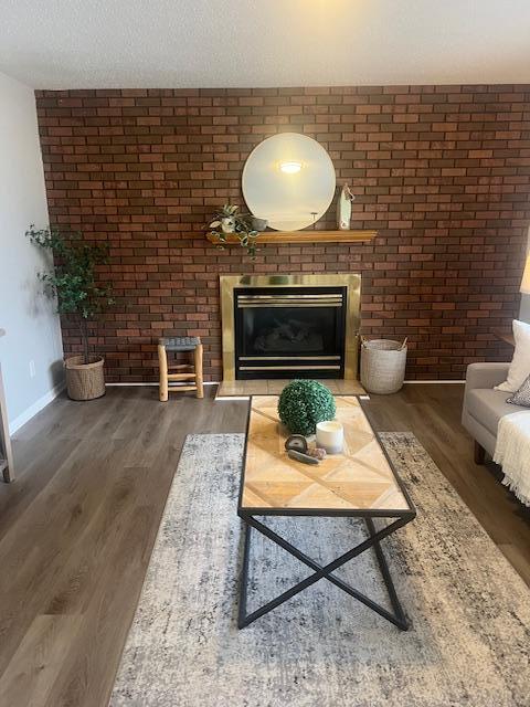 4207 Fillmore St NE, Columbia Heights, MN 55421 - living room with wood finished floors, a brick fireplace, baseboards, and brick wall