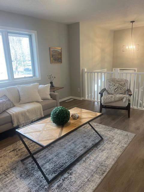 4207 Fillmore St NE, Columbia Heights, MN 55421 - living area with wood finished floors, a chandelier, and baseboards