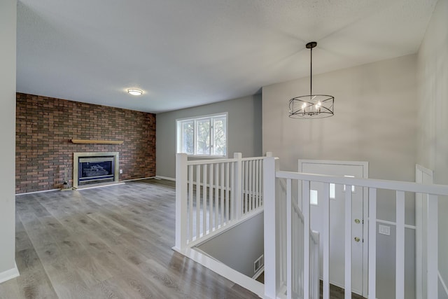 4207 Fillmore St NE, Columbia Heights, MN 55421 - hall featuring an upstairs landing, a chandelier, wood finished floors, brick wall, and baseboards