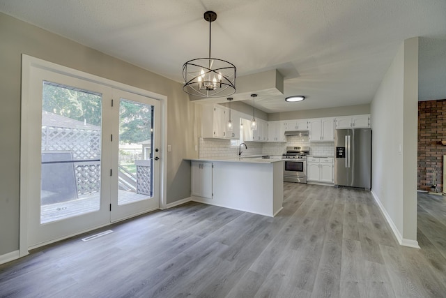 4207 Fillmore St NE, Columbia Heights, MN 55421 - kitchen featuring appliances with stainless steel finishes, a peninsula, light wood finished floors, white cabinets, and tasteful backsplash