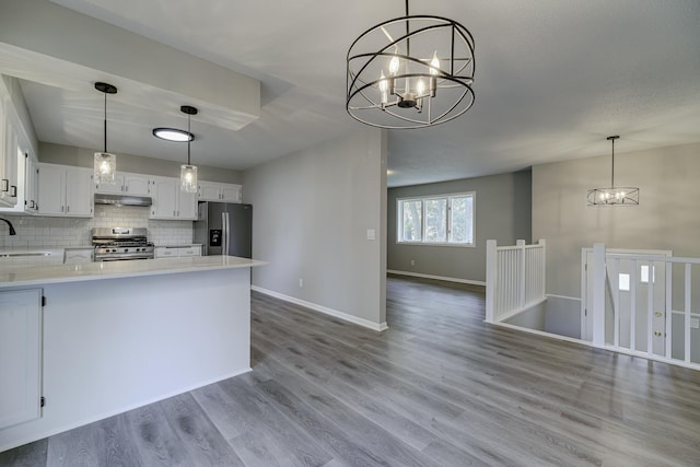 4207 Fillmore St NE, Columbia Heights, MN 55421 - kitchen featuring appliances with stainless steel finishes, under cabinet range hood, a sink, a chandelier, and open floor plan