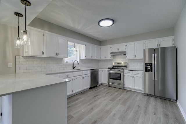 4207 Fillmore St NE, Columbia Heights, MN 55421 - kitchen with appliances with stainless steel finishes, under cabinet range hood, a sink, light wood-style floors, and white cabinets