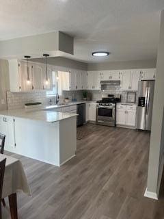 4207 Fillmore St NE, Columbia Heights, MN 55421 - kitchen with stainless steel appliances, a peninsula, decorative backsplash, white cabinets, and light countertops