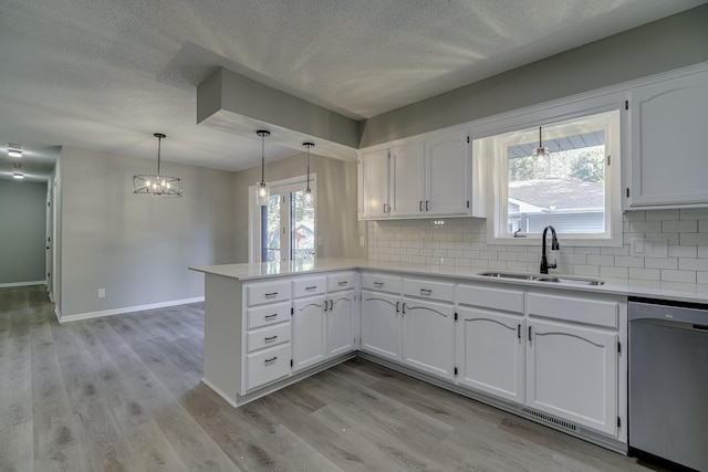 4207 Fillmore St NE, Columbia Heights, MN 55421 - kitchen with dishwasher, a sink, a peninsula, backsplash, and a textured ceiling
