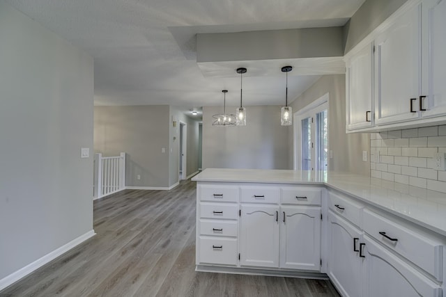4207 Fillmore St NE, Columbia Heights, MN 55421 - kitchen with a peninsula, light wood-type flooring, white cabinetry, and tasteful backsplash