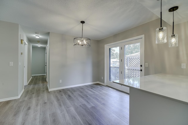 4207 Fillmore St NE, Columbia Heights, MN 55421 - unfurnished dining area with light wood finished floors, baseboards, a textured ceiling, and a chandelier