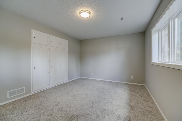 4207 Fillmore St NE, Columbia Heights, MN 55421 - unfurnished bedroom featuring carpet flooring, baseboards, a textured ceiling, and a closet