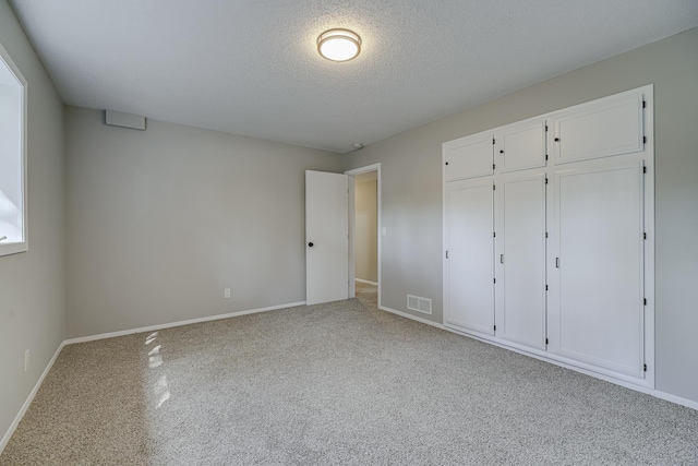 4207 Fillmore St NE, Columbia Heights, MN 55421 - unfurnished bedroom featuring carpet, baseboards, a textured ceiling, and a closet