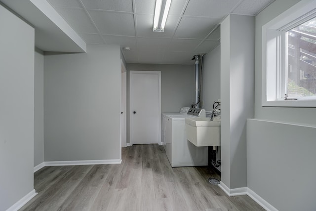 4207 Fillmore St NE, Columbia Heights, MN 55421 - laundry room with light wood-style floors, separate washer and dryer, healthy amount of natural light, and baseboards