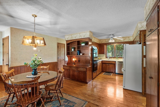 4017 Kentucky Ave N, Crystal, MN 55427 - dining room featuring wainscoting, a textured ceiling, light wood-style floors, wood walls, and ceiling fan