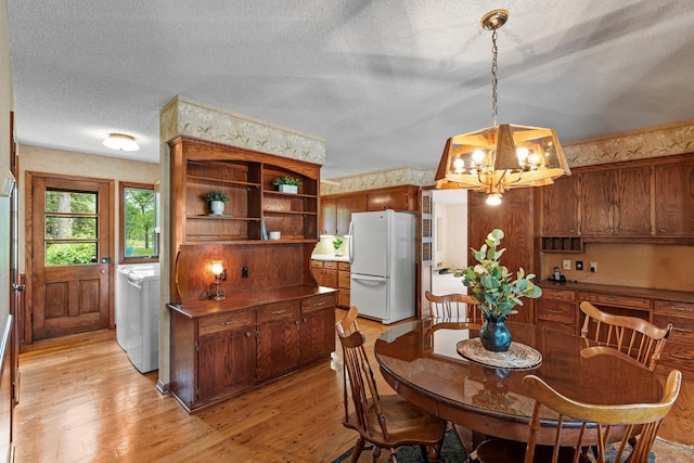 4017 Kentucky Ave N, Crystal, MN 55427 - dining room featuring a chandelier, a textured ceiling, light wood-style flooring, and washer and clothes dryer