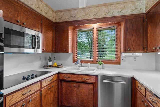 4017 Kentucky Ave N, Crystal, MN 55427 - kitchen with stainless steel appliances, a sink, light countertops, and brown cabinets