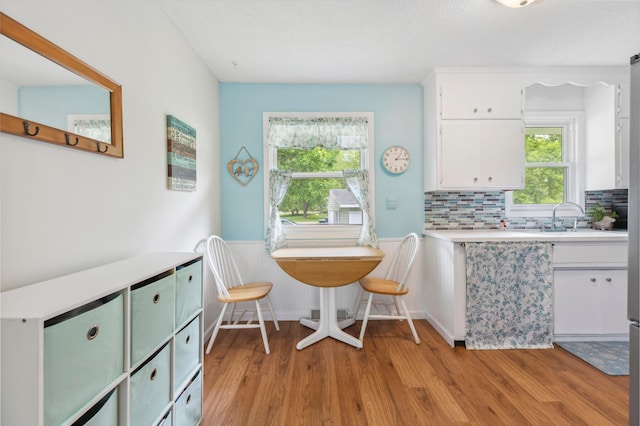 1224 N St NE, Brainerd, MN 56401 - dining area with light wood-type flooring and a wainscoted wall