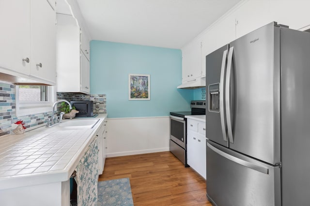 1224 N St NE, Brainerd, MN 56401 - kitchen featuring stainless steel appliances, a sink, tile countertops, under cabinet range hood, and white cabinetry