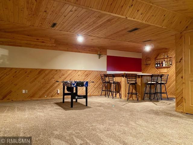 23110 Grandview Loop, Long Prairie Twp, MN 56347 - indoor dry bar featuring wooden walls, wood ceiling, and carpet