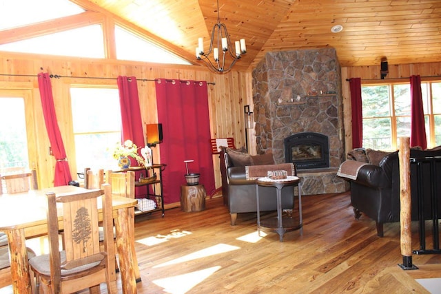 1729 Quail Ln NE, Longville, MN 56655 - living room with lofted ceiling, a chandelier, wood walls, wood finished floors, and a fireplace