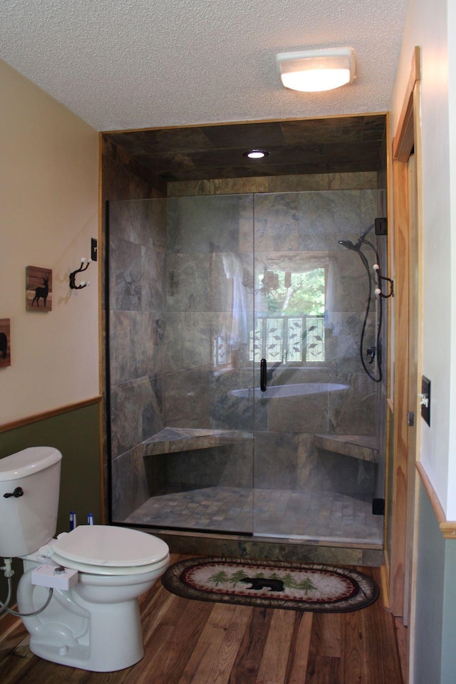 1729 Quail Ln NE, Longville, MN 56655 - bathroom featuring toilet, a stall shower, a textured ceiling, and wood finished floors