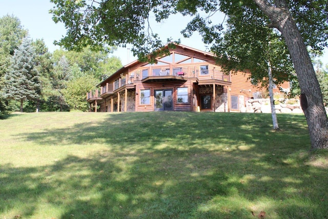 1729 Quail Ln NE, Longville, MN 56655 - back of house with a lawn, stone siding, and a wooden deck