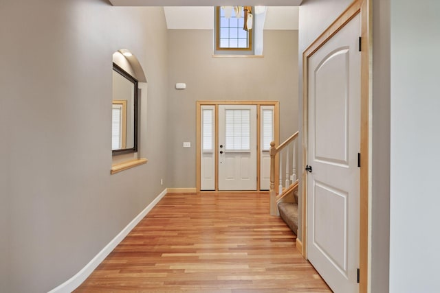 9885 Troy Ln N, Maple Grove, MN 55311 - foyer entrance featuring light wood-style flooring, baseboards, stairs, and a high ceiling