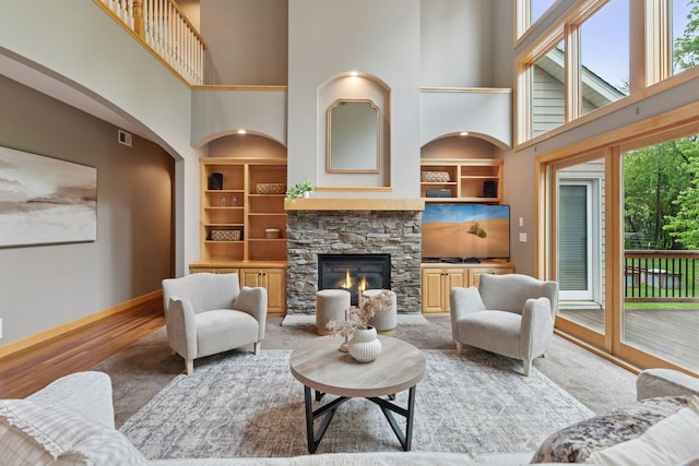 9885 Troy Ln N, Maple Grove, MN 55311 - living room with a towering ceiling, built in shelves, baseboards, a fireplace, and wood finished floors